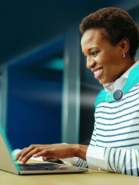 Professional woman working on laptop in modern office with headset using AI customer support tools